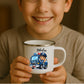 Kind hält weiße Emaille Kindertasse mit silbernem Rand – personalisierte Tasse mit Namen und süßem Motiv
