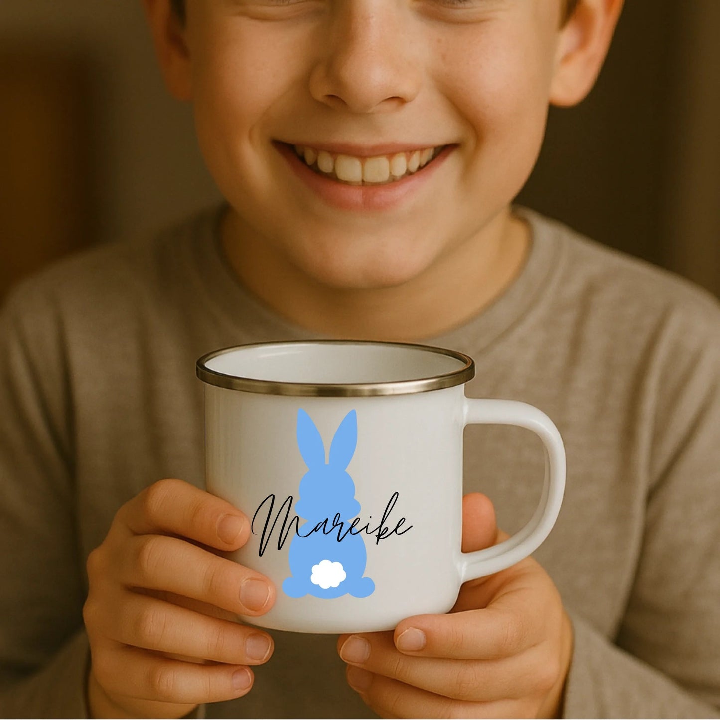 Kind hält weiße Emaille Kindertasse mit silbernem Rand – personalisierte Tasse mit Namen und süßem Motiv